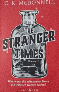 Das Cover des Romans "The Stranger Times" von C.K. McDonnel zeigt eine Flasche mit verschiedenen kleinen Figuren