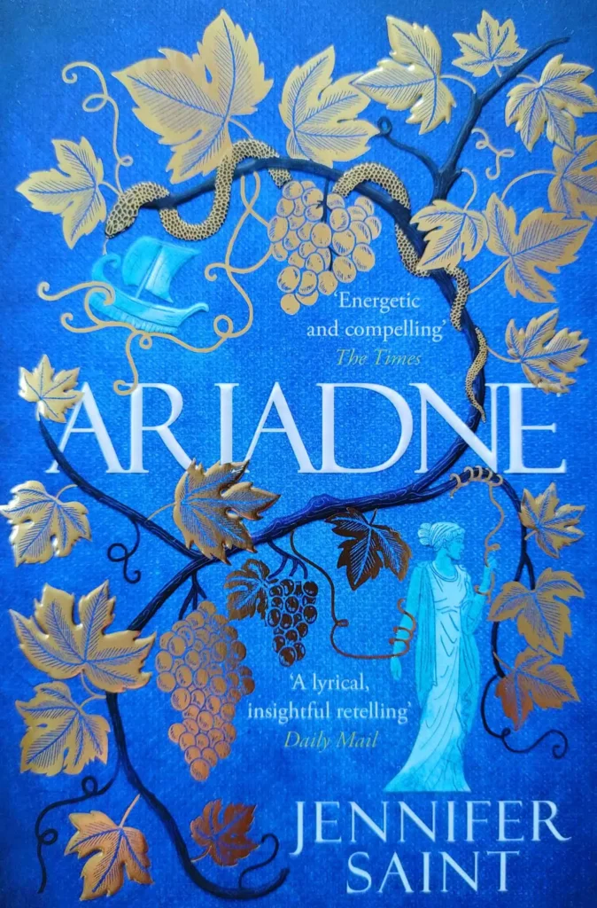 Das Cover des Romans "Ariadne" von Jennifer Saint zeigt die titelgebende Hauptfigur, ein Schiff sowie eine Schlange in einer Weinrebe.